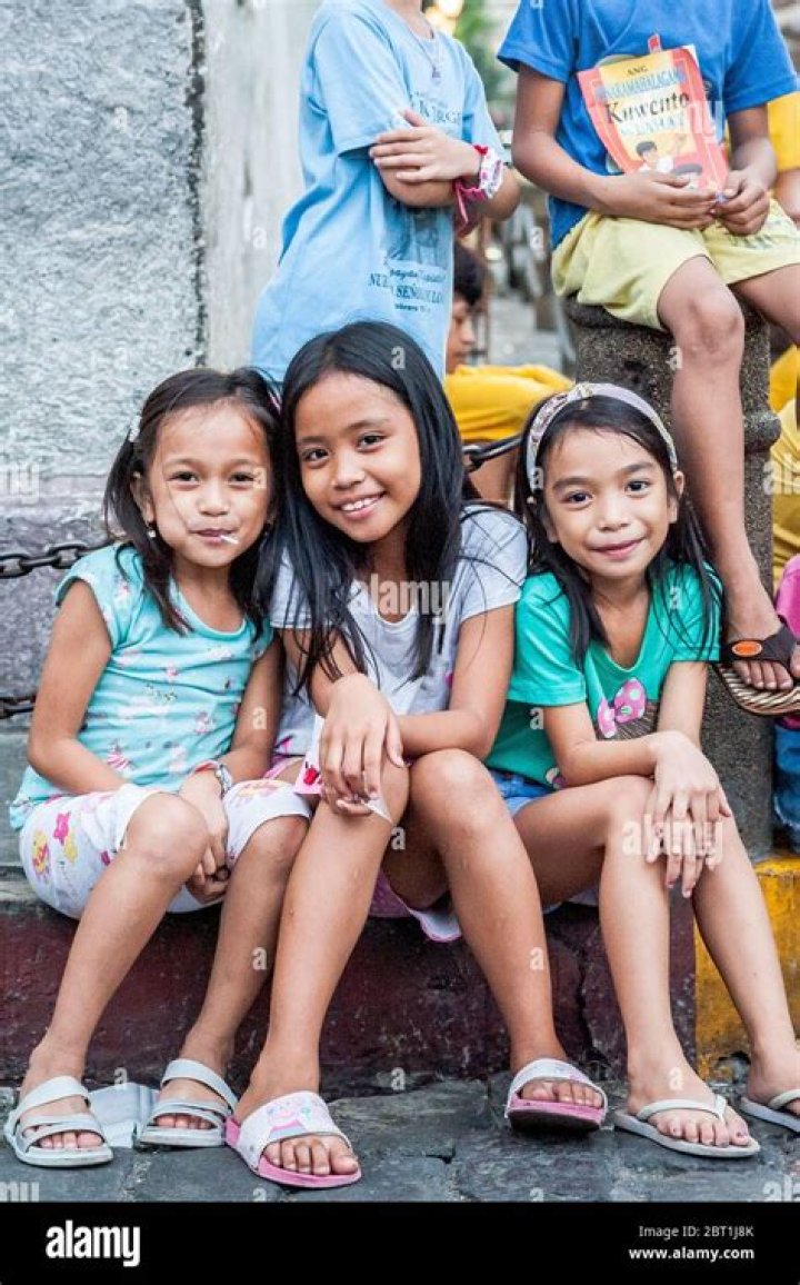 Hundreds of Filipino children sitting, pointing, and laughing