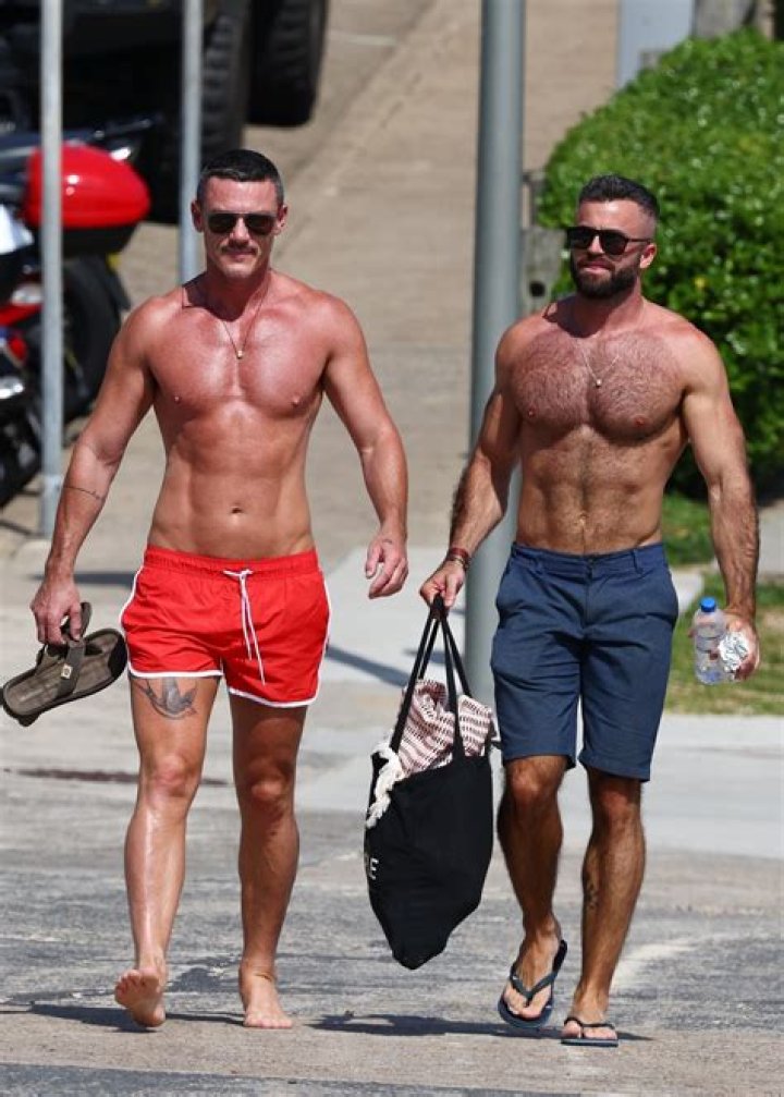 Luke Evans flaunts his abs during a beach day