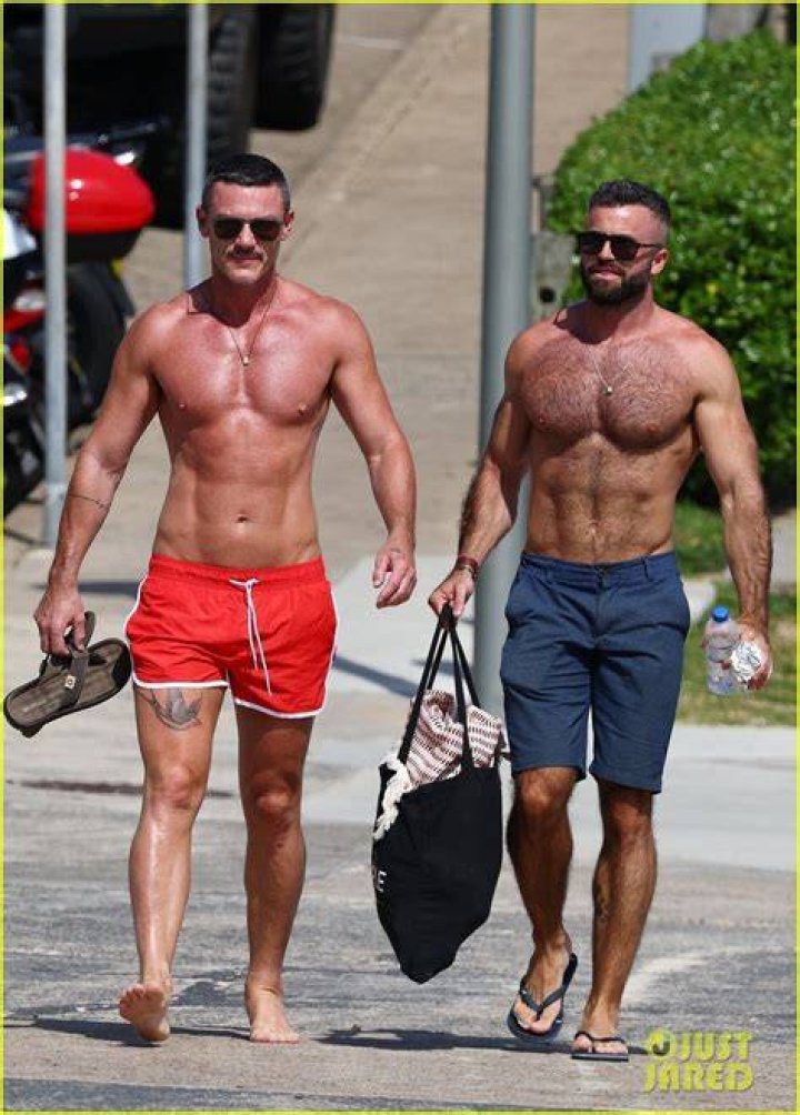 Luke Evans shows off new tattoo as he hits the beach with mystery pal