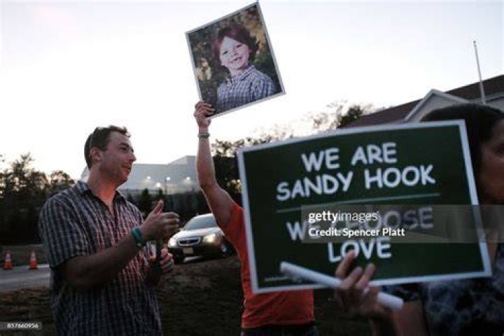 Mark Barden holds up a picture of his son Daniel who was killed in the Sandy Hook massacre, during a vigil remembering the 59 people killed. Photo / Getty Images