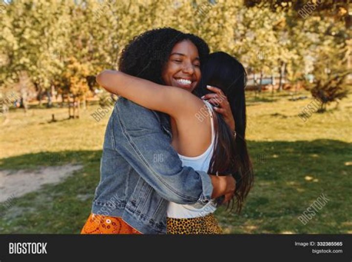 People hugging and posing in front of waterfall