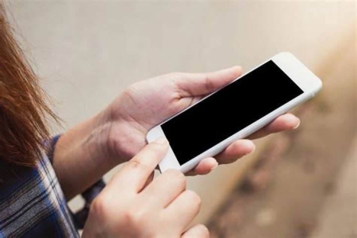 person holding iPhone displaying scenic houses abroad