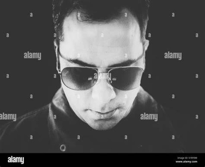 person wearing sunglasses looking down at a map