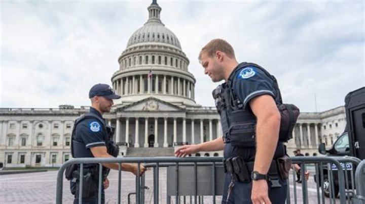US Capitol Police draw guns near a barricaded door as protesters try to break into the House Chamber. Photo / AP 