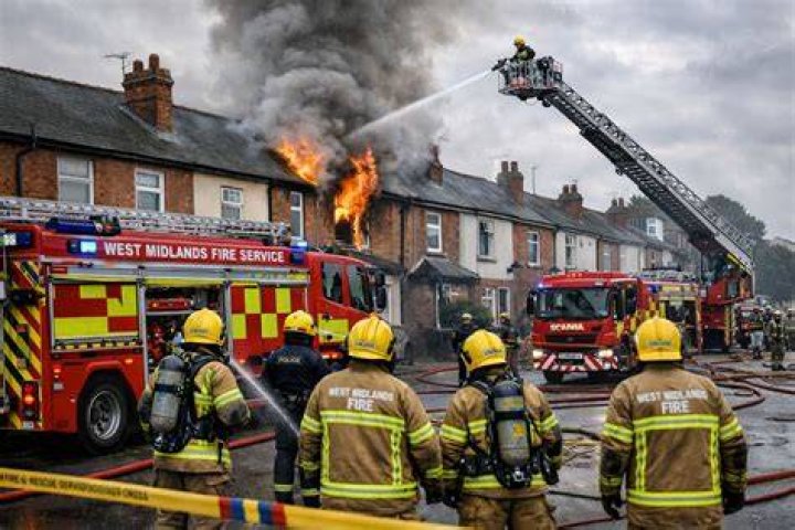 West Midlands fire officers try to free the microwave from Swingler's head. Photo / West Midlands Fire Service
